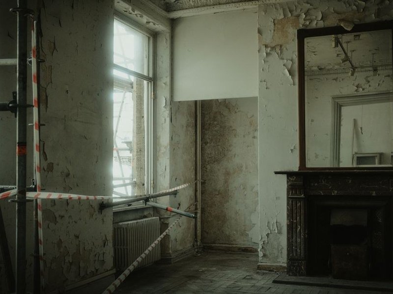 Cage d'escalier à double hauteur d'une maison de Chaponost repeinte depuis un échafaudage, plafond haut et murs remis en peinture