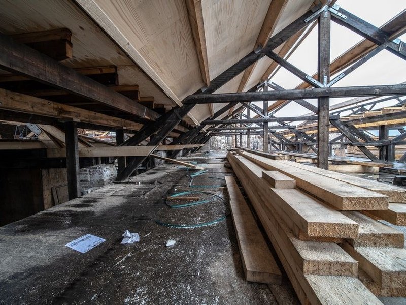 Grande dépendance de ferme en cours de rénovation à Chevinay, charpente et planches de bois avant la remise en peinture du volume