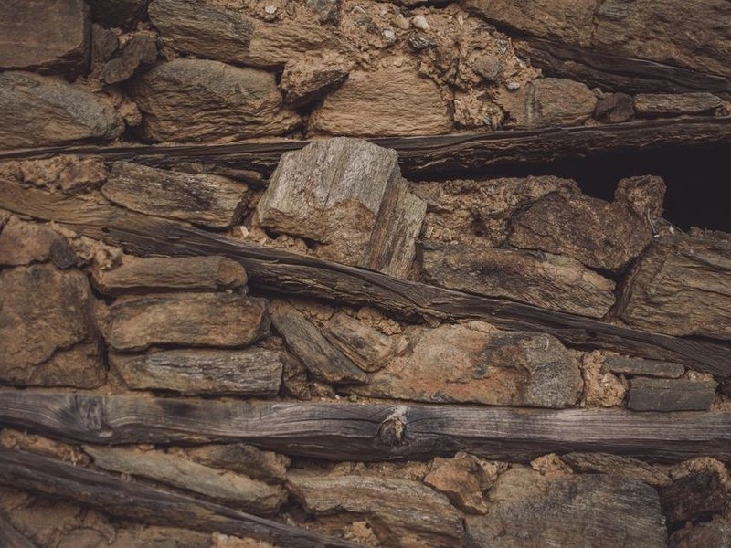 Préparation d'un vieux mur de pierre d'une maison de hameau à Chevinay, purge et comblement d'un support enduit à la chaux avant peinture