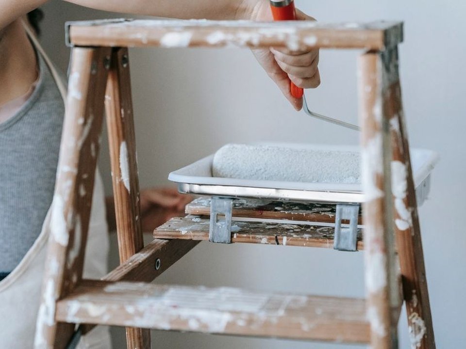 Artisan peintre appliquant une sous-couche au rouleau sur un mur en placo neuf d'un appartement récent livré à Décines-Charpieu, première mise en peinture personnalisée après livraison
