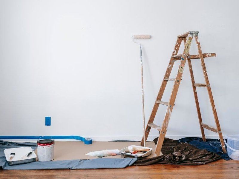 Grand séjour de villa d'Écully protégé par des bâches, échelle et rouleau en place, avant la mise en peinture des grands murs