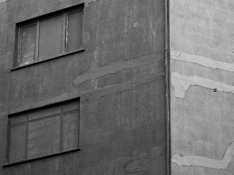 Façade crépie d'un pavillon de Fontaines-Saint-Martin nettoyée et reprise depuis un échafaudage, microfissures rebouchées avant remise en peinture sur le plateau