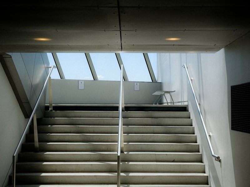 Cage d'escalier d'un pavillon de Genay repeinte en teinte claire, nez de marches et rampe protégés, montée laissée praticable