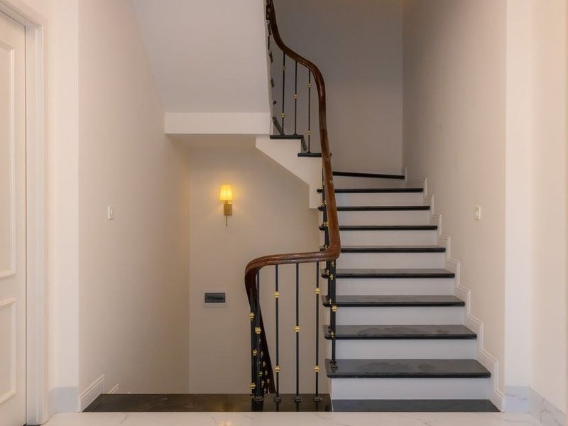Cage d'escalier menant aux chambres d'un pavillon de lotissement à Genay, murs repeints en teinte claire et finition lessivable