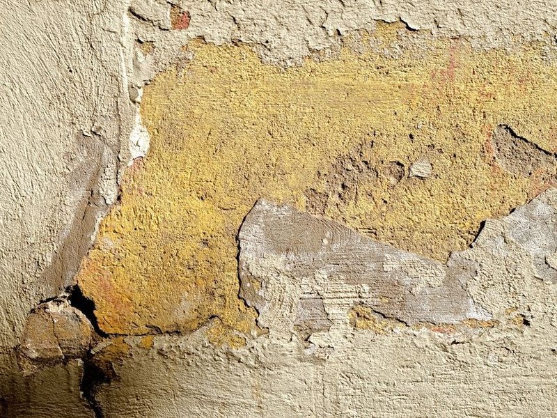 Mur ancien en pierre d'une maison du cœur de bourg de Grézieu-la-Varenne enduit au plâtre, sondé et calfeutré avant peinture respirante