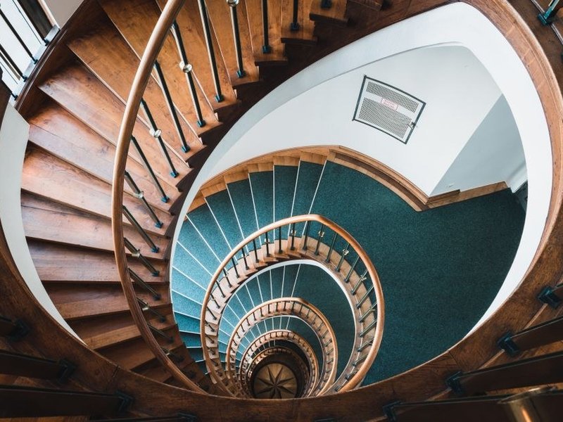 Cage d'escalier commune d'un immeuble ancien de La Mulatière repeinte sur échafaudage, plâtres repris et rampe protégée