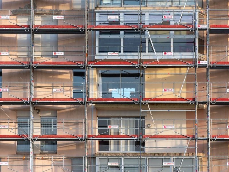 Grande façade enduite d'une propriété boisée de Lentilly démoussée et ravalée sur échafaudage, arbres tout autour