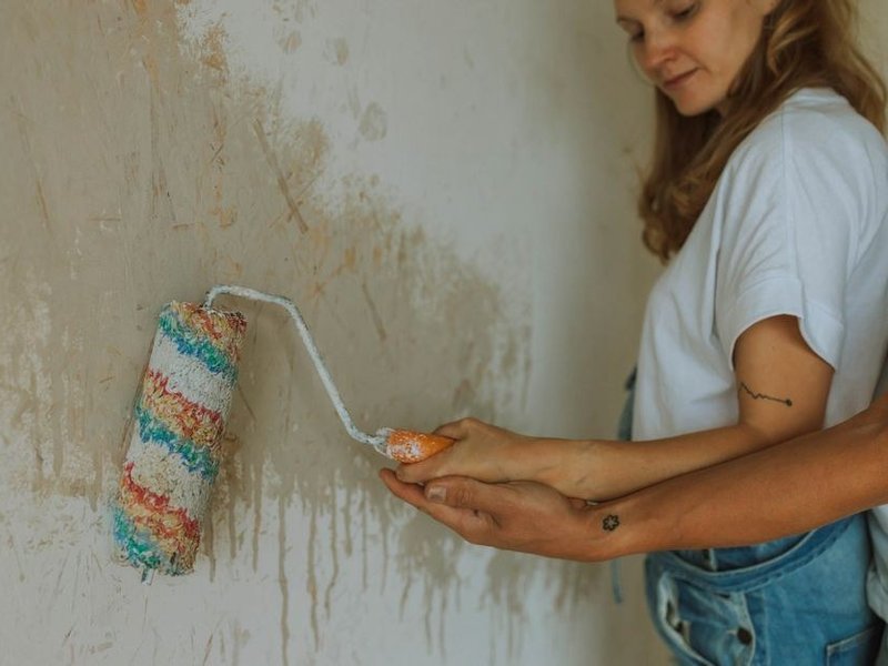 Application d'une peinture respirante au rouleau sur un mur ancien poreux consolidé d'un appartement de la Croix-Rousse à Lyon 4e