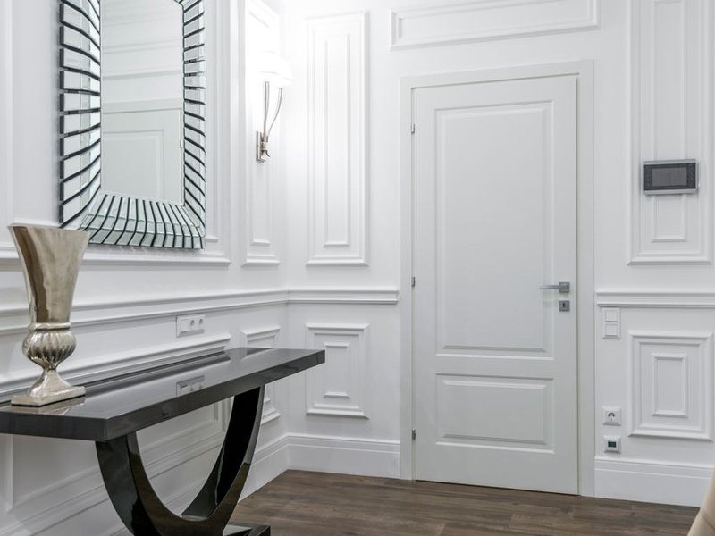 Portes à double battant et boiseries anciennes repeintes en laque satinée dans un appartement de réception haussmannien de Lyon 6e, parquet protégé