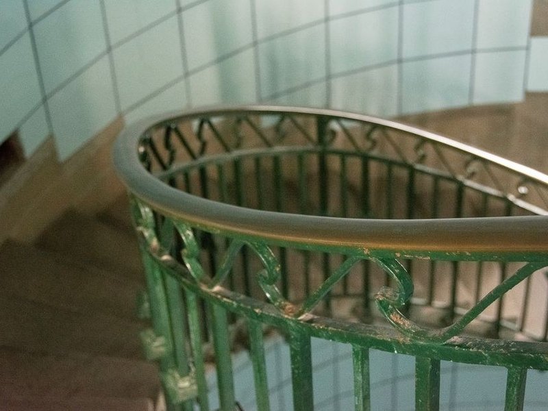 Cage d'escalier commune de standing d'un immeuble haussmannien de Lyon 6e repeinte, rampe en fer forgé préservée et marches protégées, parties communes de copropriété