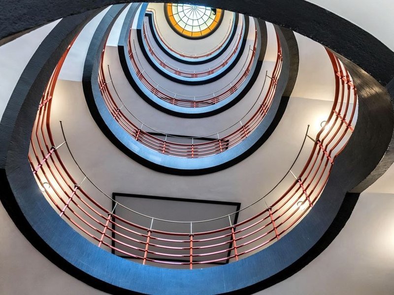 Cage d'escalier d'un immeuble de l'entre-deux-guerres du 8e arrondissement de Lyon remise en peinture, lignes sobres Art déco et murs en plâtre repris