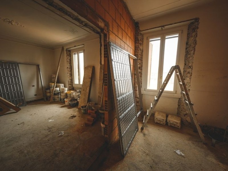 Mur de plâtre épais ancien fissuré d'une maison du cœur du village de Marennes, à reboucher et poncer avant peinture
