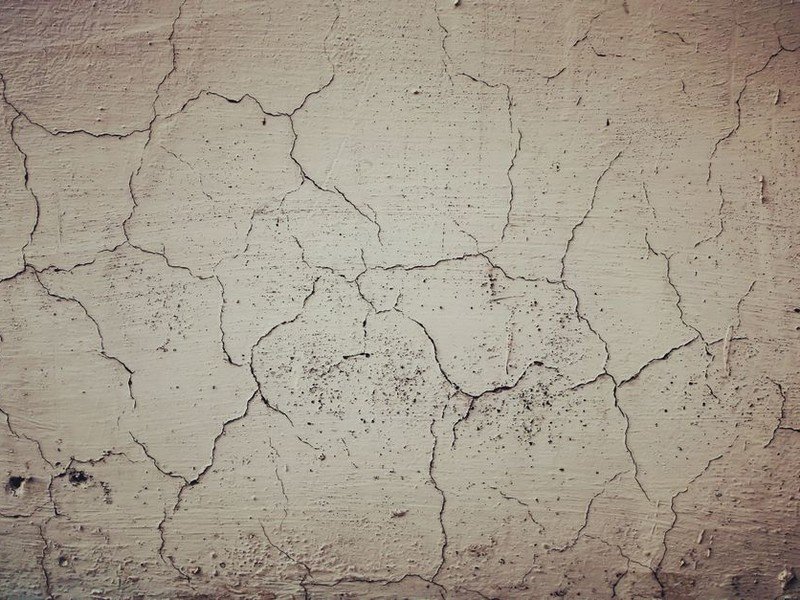 Reprise à l'enduit d'une fissure de retrait dans le plâtre ancien d'une maison de ville d'Oullins avant mise en peinture