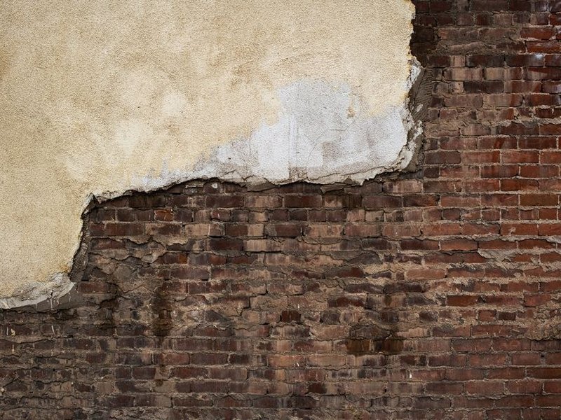 Ravalement d'une maison de bourg ancienne en pierre enduite à la chaux à Pollionnay, enduit sondé et repris avant finition perméable