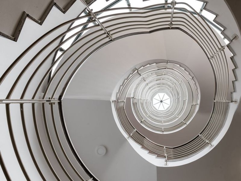 Mise en peinture d'une cage d'escalier à double hauteur dans un pavillon de lotissement de Saint-Bonnet-de-Mure, arêtes nettes le long du limon