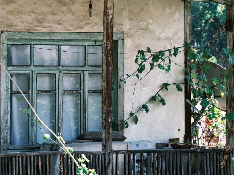 Ravalement de la façade en enduit d'une maison de bourg ancienne du centre de Saint-Genis-Laval, reprise des fissures et remise en peinture dans un ton clair