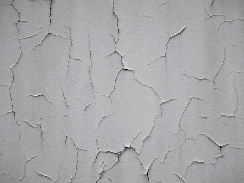 Mur de plâtre ancien fissuré d'une maison du vieux bourg de Saint-Pierre-de-Chandieu, à reboucher et poncer avant peinture