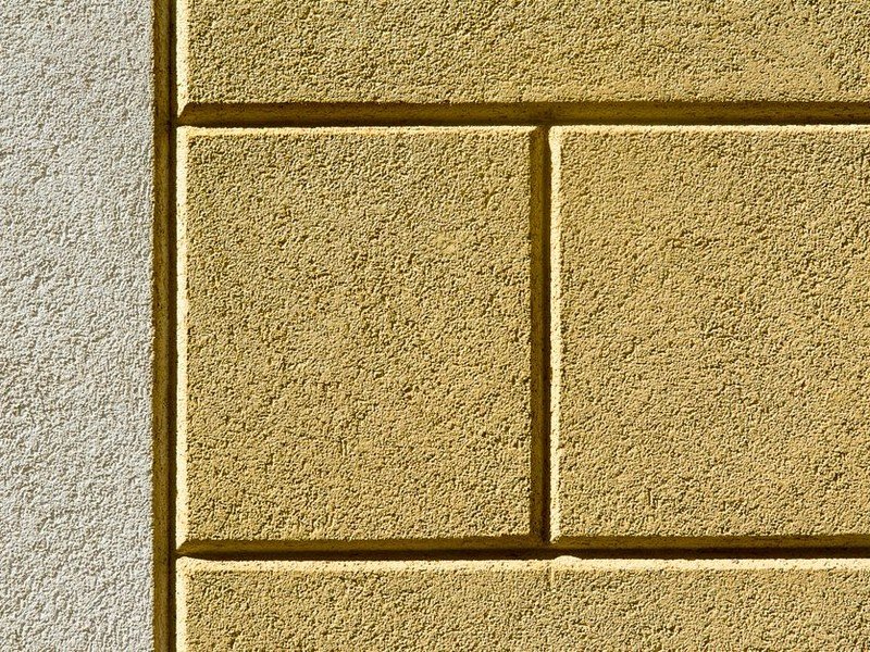 Rafraîchissement de la façade enduite d'un pavillon de Saint-Priest, application au rouleau d'une peinture de façade microporeuse sur le mur extérieur