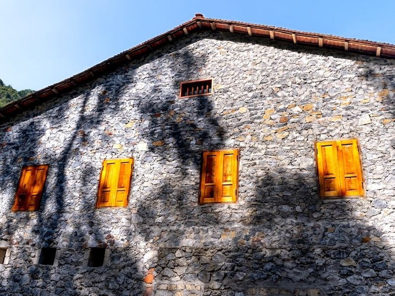 Façade en pierre d'une maison ancienne du vieux village de Sathonay-Village nettoyée en douceur et reprise à la chaux avant un revêtement minéral respirant