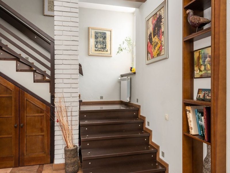 Cage d'escalier en bois et grand volume d'une maison meulière de Tassin repeints depuis une plateforme intérieure, rampe et boiseries préservées
