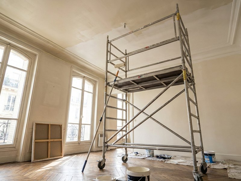 Peinture d'un plafond haut depuis un échafaudage intérieur dans un immeuble des années 30 à Villeurbanne