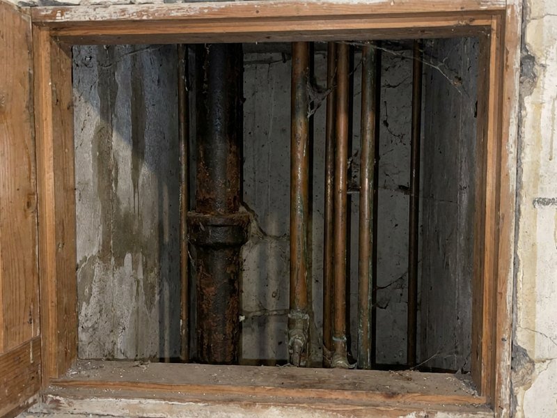 Colonne montante ancienne dans la gaine technique d'un immeuble en copropriété à Lyon 6