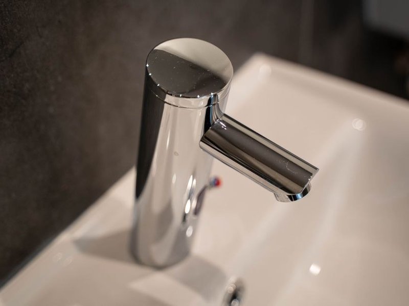 Mitigeur thermostatique neuf et lavabo moderne posés dans la salle de bain d'un pavillon des années 2000 à Meyzieu