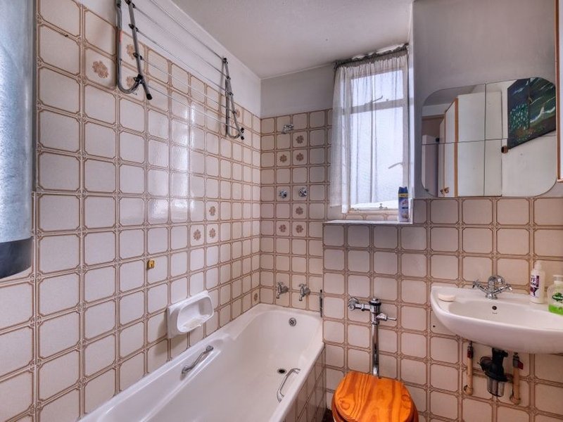 Salle de bain à moderniser avec robinetterie et faïence datées dans un pavillon de Saint-Priest