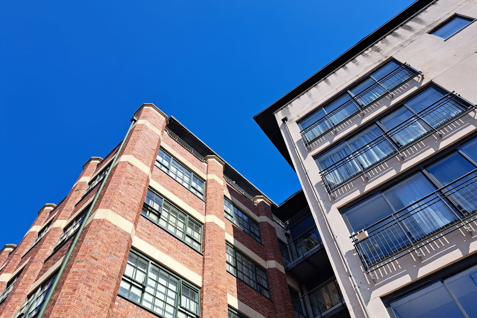 Façade d'immeuble rénovée en brique et enduit clair à Lyon