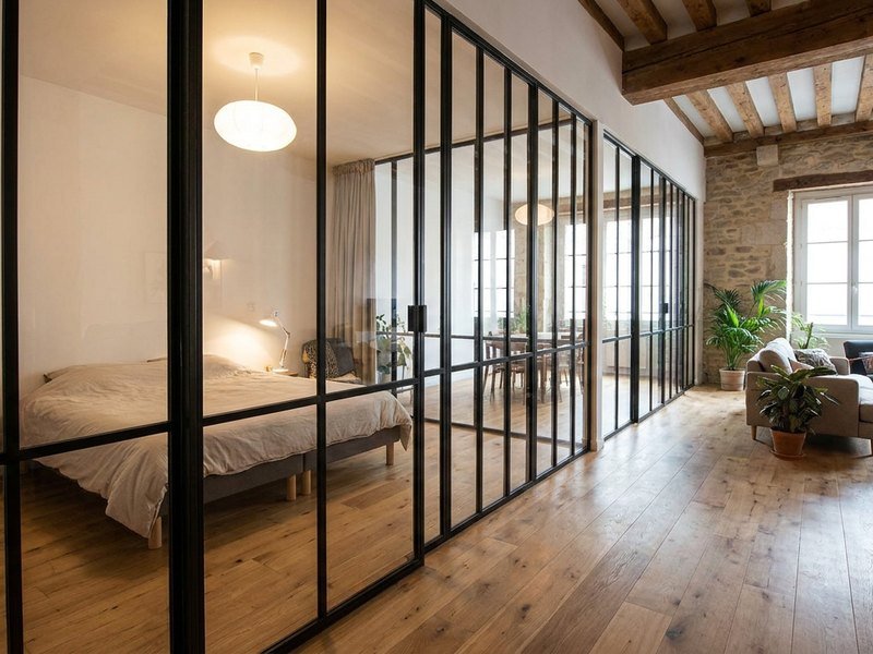 Verrière d'atelier en acier noir séparant une chambre du séjour dans un loft de la Croix-Rousse