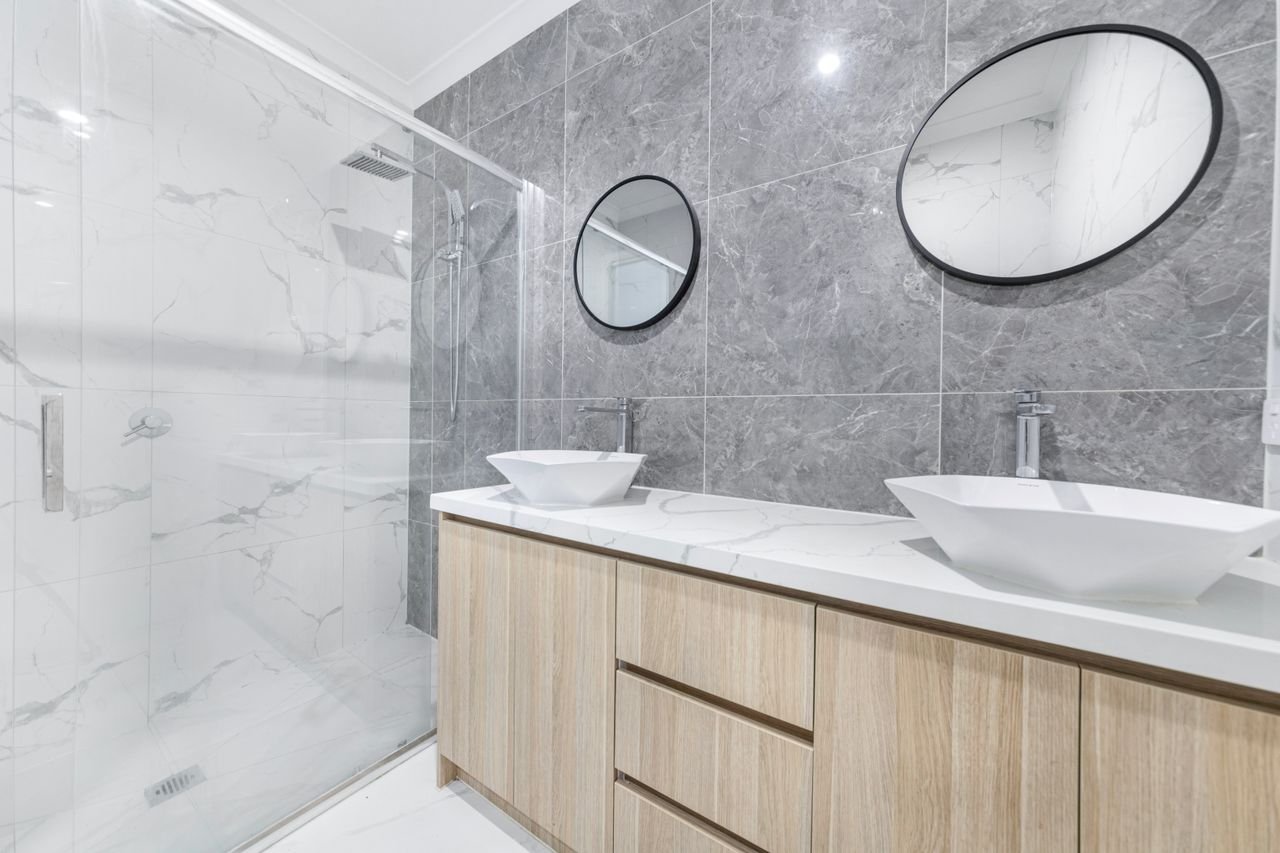 Salle de bain rénovée à Lyon : double vasque, meuble bois et douche carrelée